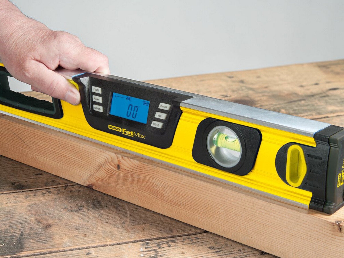 Poziomica elektroniczna STANLEY Fatmax 0-42-065, precyzja, wymiary, pion, poziom, poziomica przyłożona do deski leżącej na blacie mierzy kąt poziomy deski
