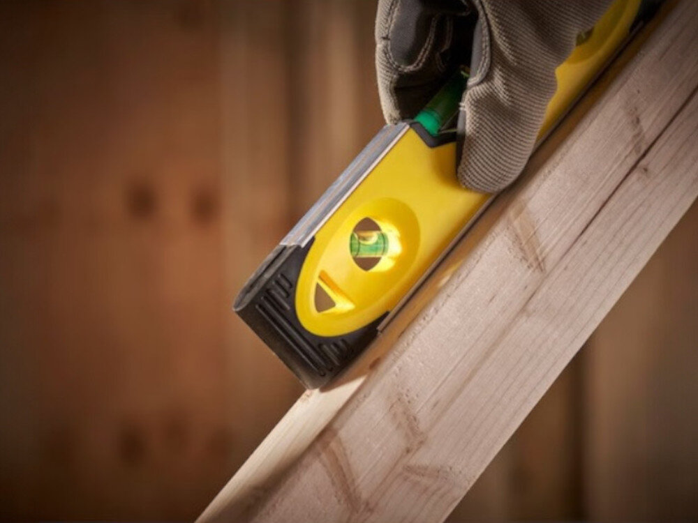 Poziomica magnetyczna STANLEY Toprpedo Shockproof 0-43-511, poziom, pomiar, precyzja, budowa, Poziomica Stanley na drewnianej belce pod kątem.