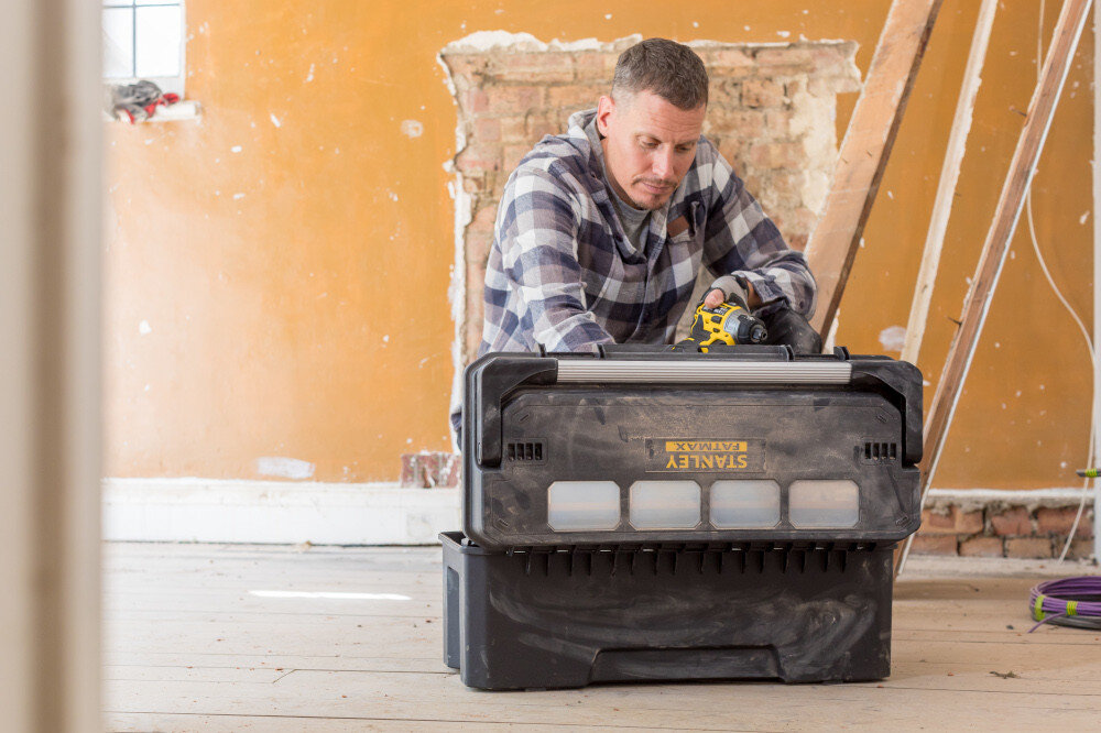 Skrzynia na narzędzia STANLEY Fatmax Pro Cantilever FMST1-75791 pomieszczenie skrzynka widoczna od tyłu obok osoba zagląda do skrzynki praktyczny gadżet pomaga uporządkować narzędzia akcesoria i drobne elementy montażowe efektywność codziennej pracy porządek