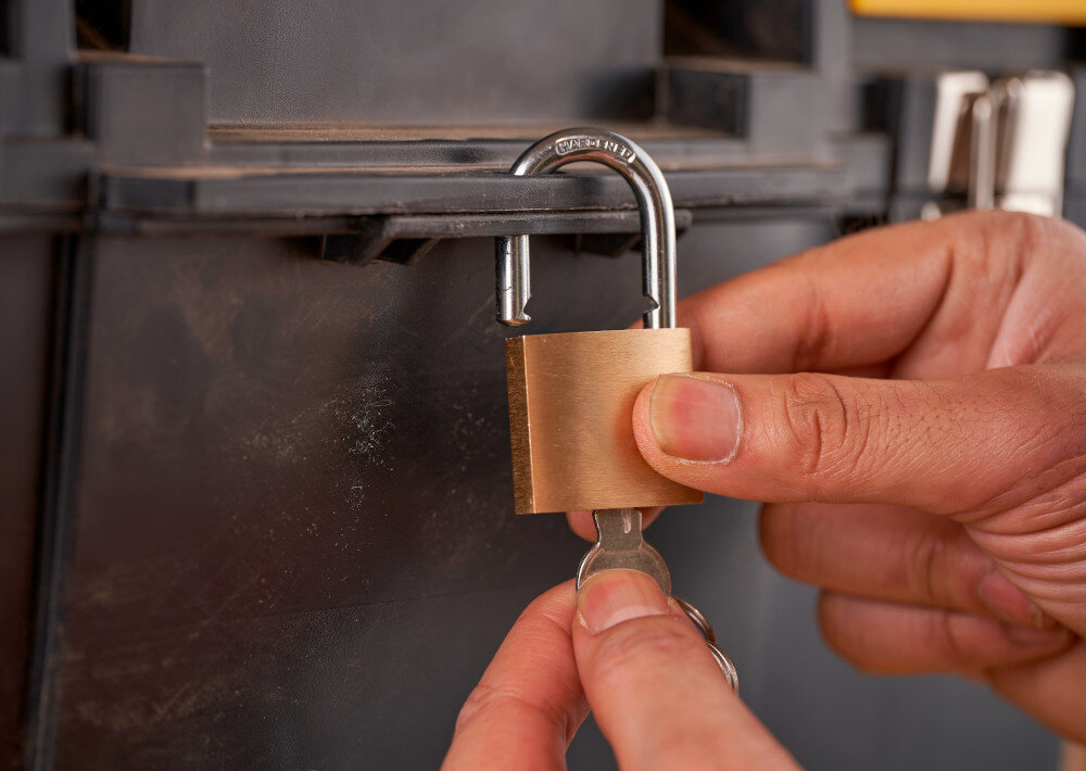 Skrzynka narzędziowa STANLEY 1-70-326 zbliżenie na otwór na kłódkę osoba zakłada kłódkę możliwość zamknięcia na kłódkę bezpieczeństwo przechowywanych narzędzi przed dostępem osób niepowołanych