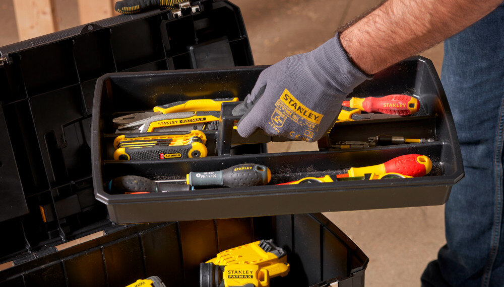 Skrzynka narzędziowa STANLEY 1-93-968 zbliżenie na tackę osoba trzyma tackę w dłoni tacka wypełniona narzędziami pod tacką stoi skrzynka praktyczna wyjmowana tacka pomaga oddzielić mniejsze akcesoria od większych narzędzi szybciej sięgnąć po potrzebne akcesoria porządek