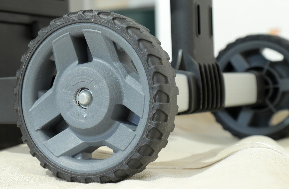 Skrzynka narzędziowa STANLEY FatMax 1-95-622 zbliżenie na koła podłoga duże koła o średnicy 7 cali teleskopowy uchwyt ogranicza ryzyko przewrócenia zmniejsza wysiłek przy przenoszeniu ciężkiego wyposażenia