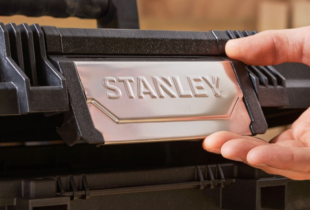 Skrzynia narzędziowa STANLEY ONE TOUCHT LATCCH 19 Z szufladą zbliżenie na zatrzask osoba trzyma zatrzask w dłoni zatrzask typu ONE HAND OPERATION szybkie otwieranie i zamykanie obsługa jedną ręką