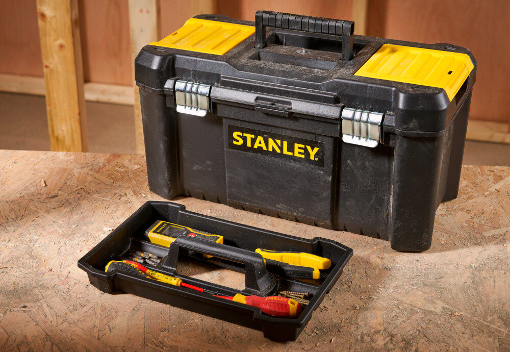 Skrzynka narzędziowa STANLEY Essential STST1-75521 skrzynka wypełniona narzędziami obok tacka drewniany bla w tle drewniana ściana porządek transport mobilność przenoszenie narzędzi