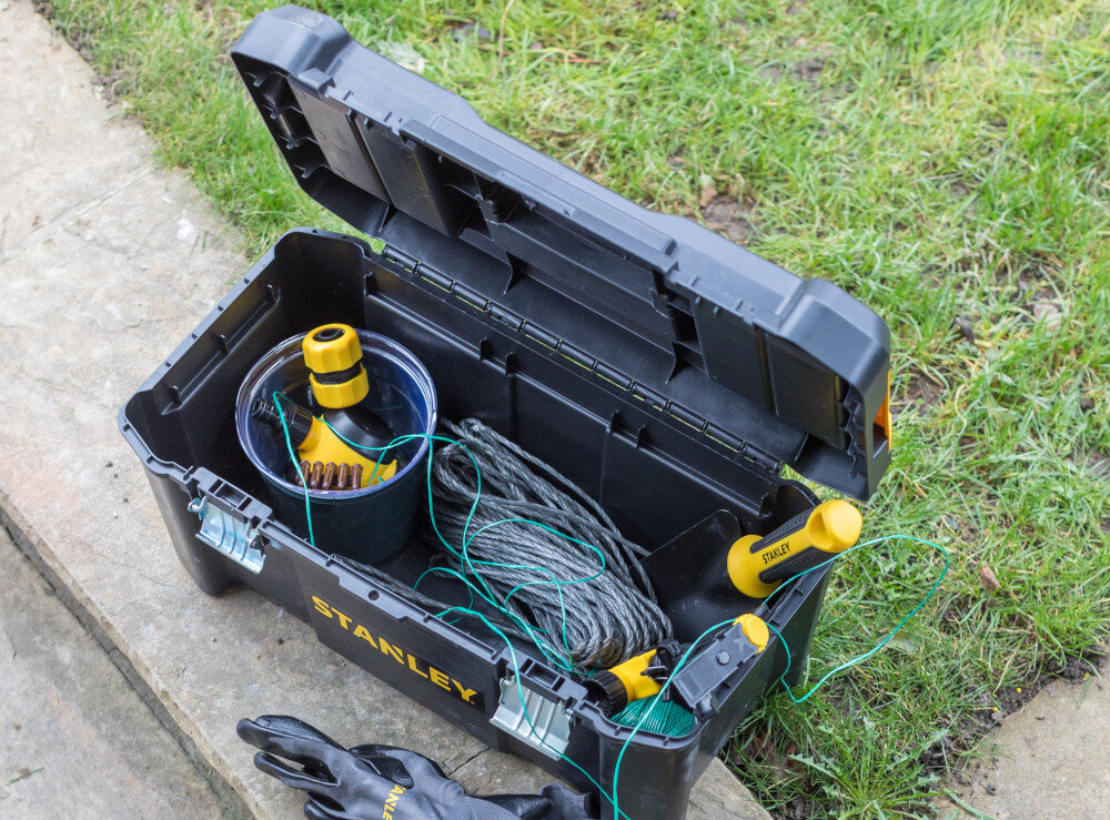 Skrzynka narzędziowa STANLEY Essential STST1-75521 otwarta skrzynia na obżerzu trawnika w tle trawa widok z góry uchwyt wymiary 480 × 250 × 250 mm waga 1,6 kg duża pojemność wytrzymałość
