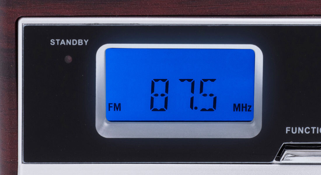 Wyświetlacz z niebieskim tłem pokazuje częstotliwość 87.5 MHz oraz oznaczenie FM. Obok znajduje się napis \'STANDBY\'.