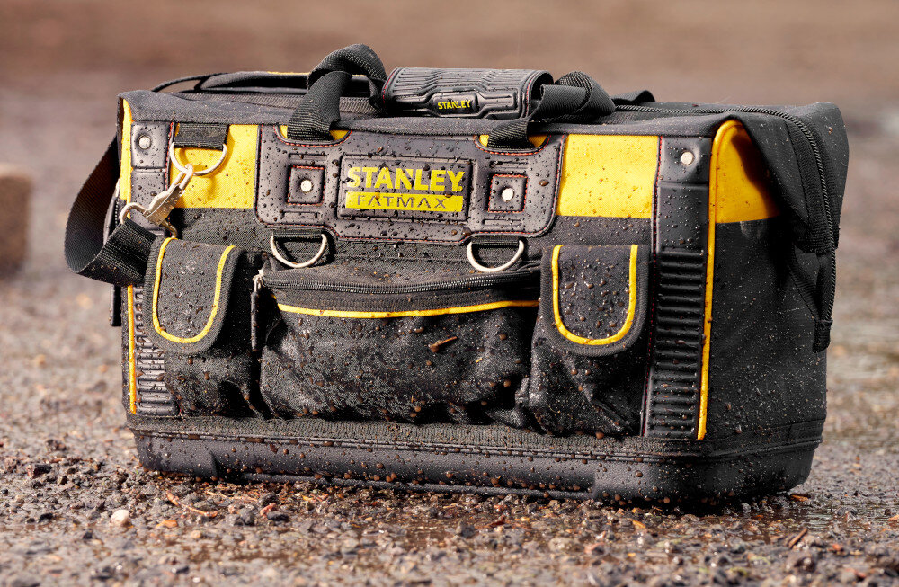 Torba narzędziowa STANLEY FMST1-71180 plac budowy torba ustawiona na mokrym podłożu torba lekko zabrudzona i mokra konstrukcje i elementy dno wykonano z wytrzymałego wodoodpornego tworzywa ochrona przed wilgocią i zabrudzeniami usztywnione panele stabilny kształt