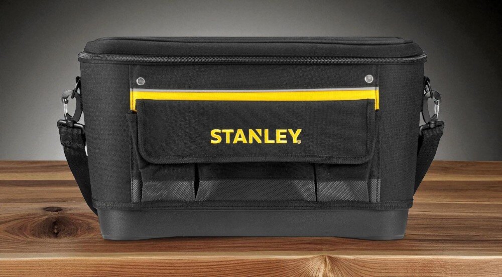 Torba narzędziowa STANLEY 1-96-193 zamknięta torba widoczna od przodu ustawiona na drewnianym blacie w tle szara ściana transport funkcjonalność mobilność porządek ochrona narzędzi