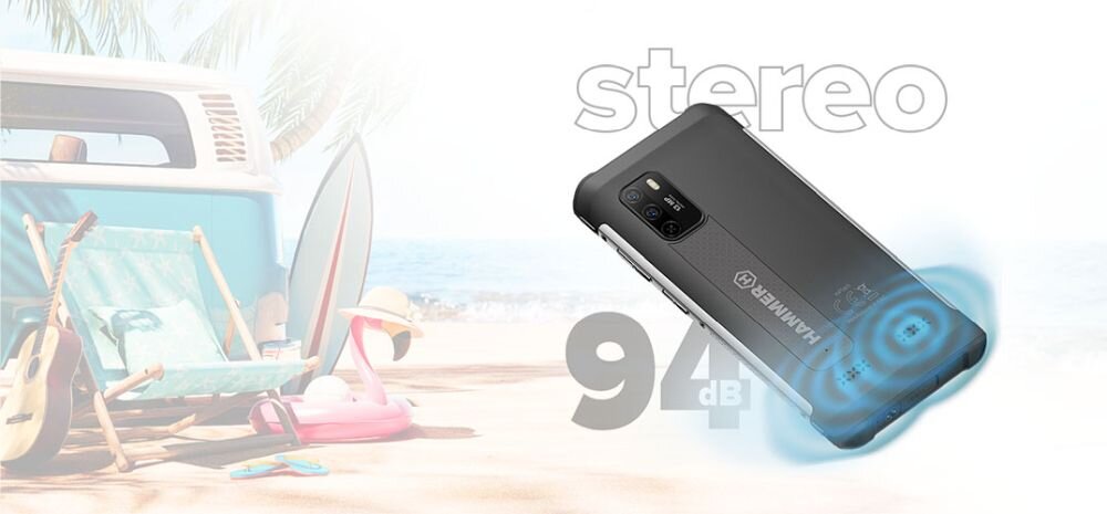 Obraz przedstawia smartfon z napisem \'HAMMER\' na plaży, obok leżaka, flaminga i gitary. Widoczny jest tekst \'stereo 94 dB\'.