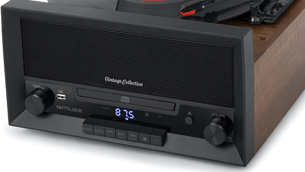 Gramofon z drewnianą obudową i czarnym panelem przednim z napisem \'Vintage Collection\'. Widoczne są pokrętła, wyświetlacz z cyframi \'87.5\' oraz logo \'muse\'.