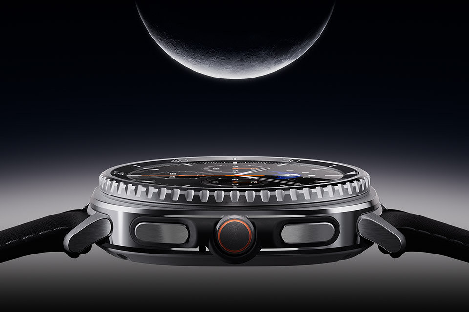 Już do nabycia w Media Expert. Galaxy Watch8 Classic jest skierowany w górę, delikatnie świecąc z księżycem nad głową. Zbliżenie na bok srebrnego smartwatcha z czarnym paskiem, z widocznymi przyciskami i pokrętłem. W tle widoczny jest fragment księżyca na ciemnym niebie.