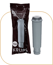 Na obrazie widoczny jest filtr do ekspresu w szarym kolorze oraz jego opakowanie z napisem \'KRUPS\'.