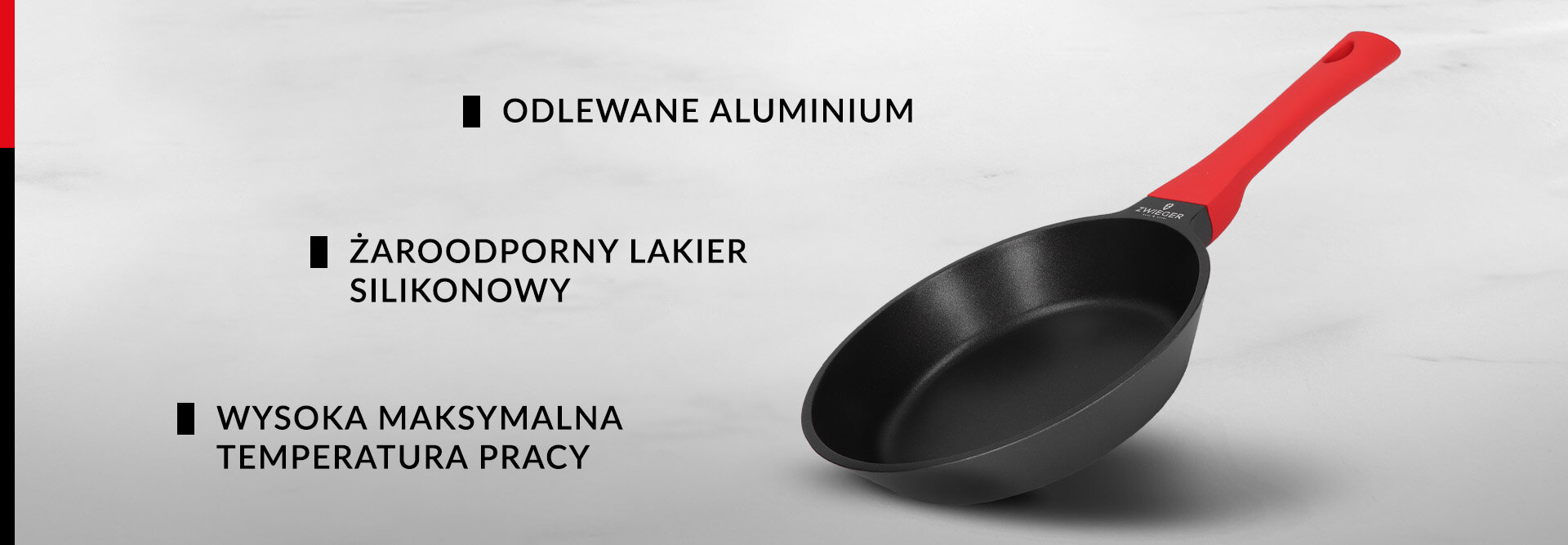 Na obrazie widoczna jest patelnia z czarną powierzchnią i czerwoną rączką. Obok znajdują się napisy: \'ODLEWANE ALUMINIUM\', \'ŻAROODPORNY LAKIER SILIKONOWY\', \'WYSOKA MAKSYMALNA TEMPERATURA PRACY\'.