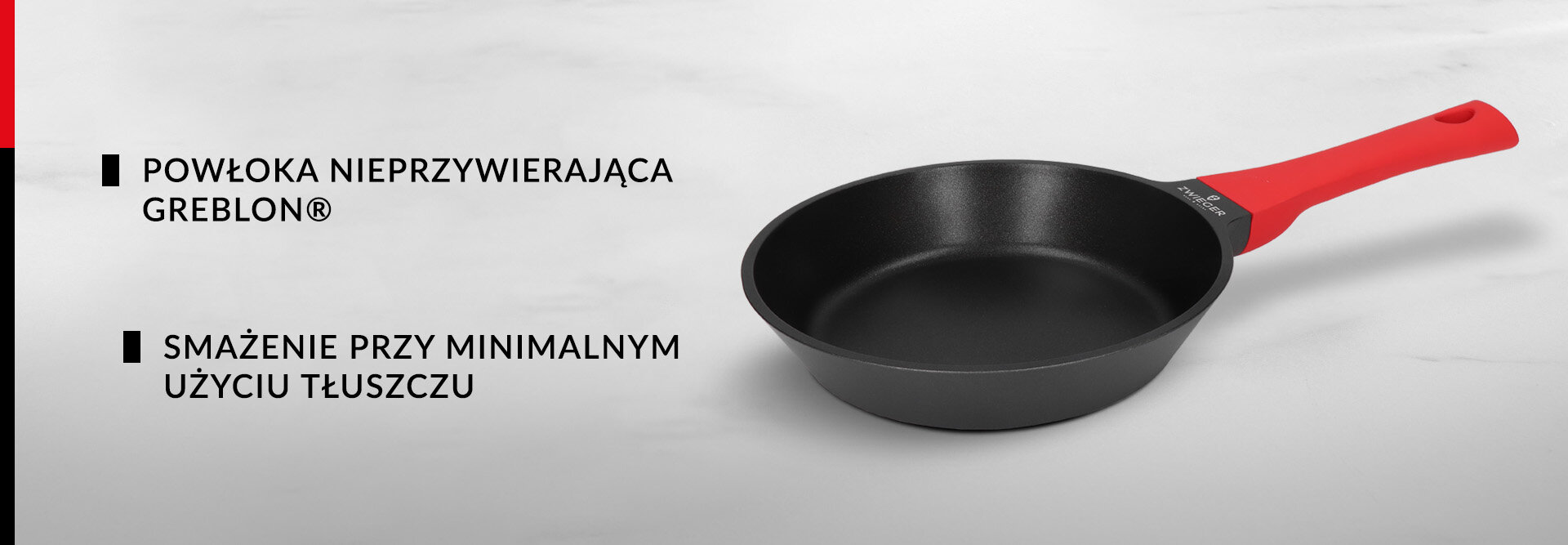Na obrazie widoczna jest czarna patelnia z czerwonym uchwytem. Obok znajduje się tekst: \'POWŁOKA NIEPRZYWIERAJĄCA GREBLON® SMAŻENIE PRZY MINIMALNYM UŻYCIU TŁUSZCZU\'.