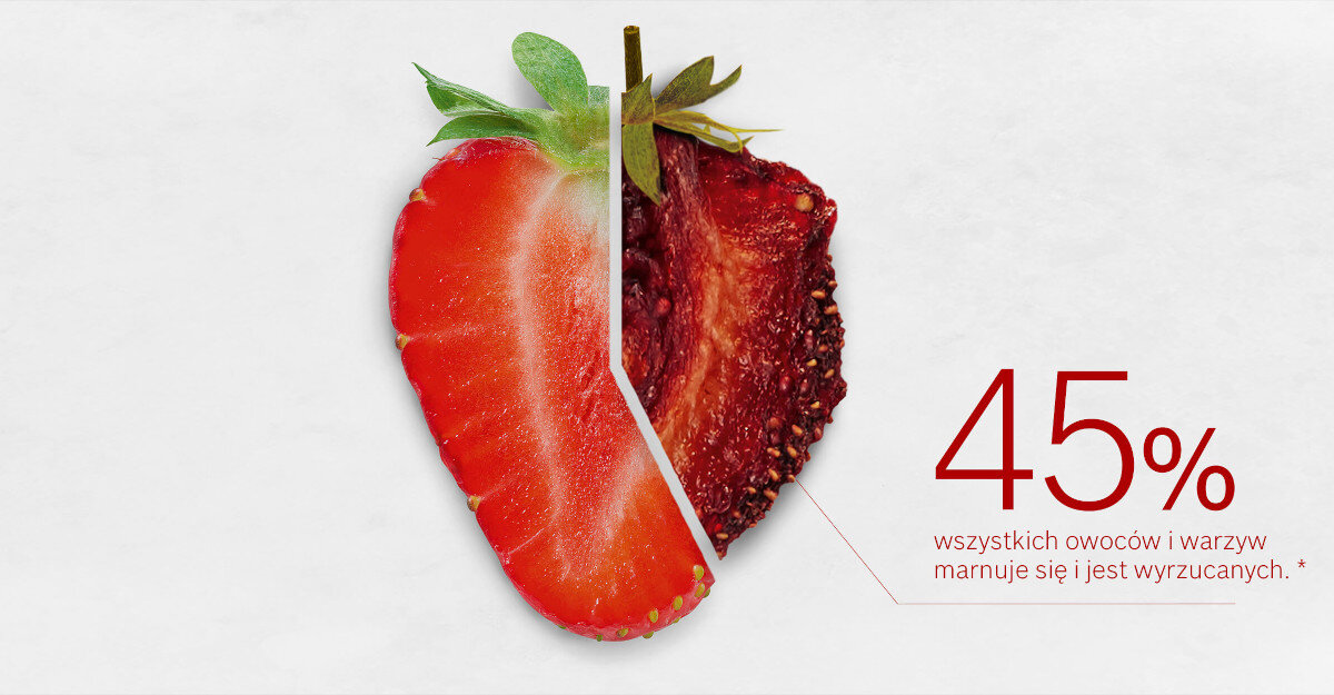 Obraz przedstawia przekrojoną truskawkę, z jednej strony świeżą, a z drugiej wysuszoną. Obok znajduje się tekst: \'45% wszystkich owoców i warzyw marnuje się i jest wyrzucanych.\'
