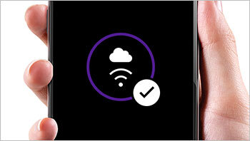 Osoba trzyma smartfon z wyświetlonym symbolem chmury i sygnału Wi-Fi w fioletowym okręgu oraz białą ikoną z zaznaczeniem wyboru.