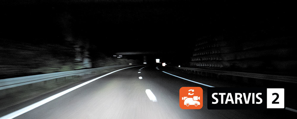 Nocna droga oświetlona reflektorami samochodu, z widocznymi liniami na jezdni. W prawym dolnym rogu znajduje się logo z napisem \'STARVIS 2\' oraz ikoną kamery.