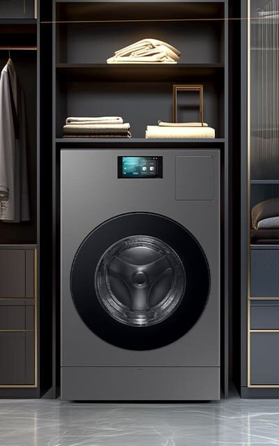 Ultrapojemna pralko-suszarka Samsung WD18DB8995BZT2 dostępna w Media Expert Pralko-suszarka w kolorze szarym z dużym, okrągłym bębnem i ekranem dotykowym na górze. W tle widoczne są półki z ręcznikami i ubraniami.