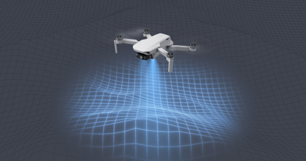 Na obrazie widoczny jest biały dron unoszący się nad siatką świetlną, która oświetla powierzchnię pod nim.