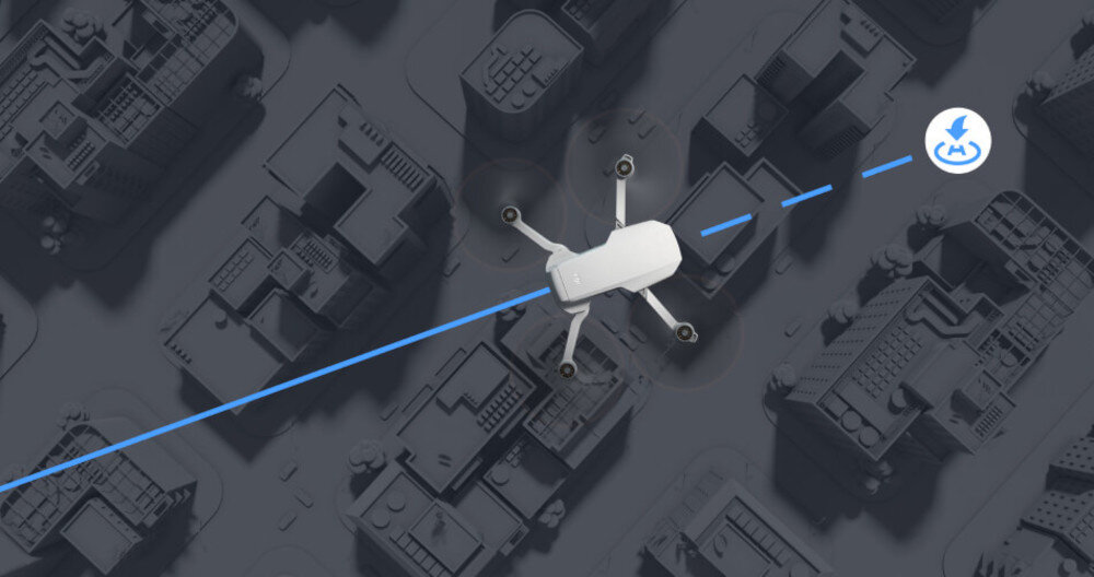 Na obrazie widoczny jest biały dron lecący nad miastem, z niebieską linią wskazującą jego trasę. W prawym górnym rogu znajduje się ikona z symbolem błyskawicy.