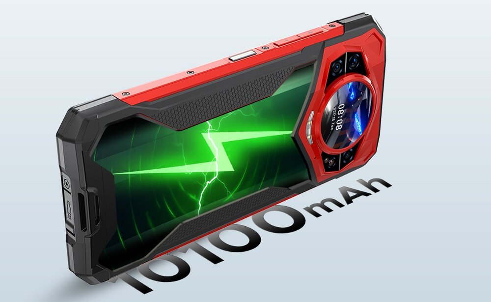 Smartfon z czerwono-czarną obudową, wyświetlający zieloną grafikę z błyskawicą na ekranie. Obok telefonu widoczny jest napis \'10100 mAh\'.