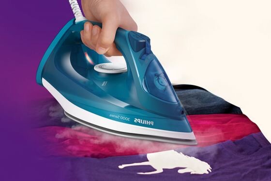 Osoba prasuje kolorowy materiał żelazkiem z napisem \'PHILIPS 3000 Series\'. Z żelazka wydobywa się para.