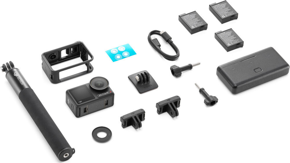 Na obrazie znajduje się zestaw akcesoriów do kamery sportowej, w tym kamera, uchwyty, baterie, kabel, etui i kijek do selfie. Widoczne jest logo \'DJI\' na kijku do selfie.