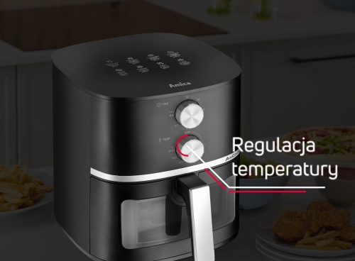 Czarna frytkownica beztłuszczowa z pokrętłem do regulacji temperatury i okienkiem do obserwacji postępów. Na górze urządzenia widoczne jest logo \'Amica\'.