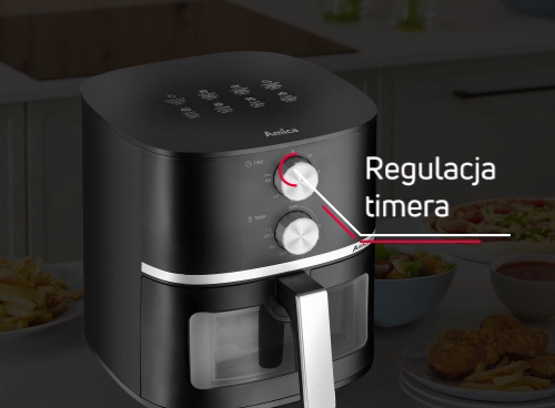 Czarna frytkownica beztłuszczowa z pokrętłem do regulacji timera, oznaczonym napisem \'Regulacja timera\'. W tle widoczne są talerze z jedzeniem.