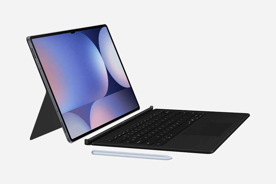 Na obrazie widoczny jest tablet z klawiaturą i rysikiem. Ekran tabletu wyświetla abstrakcyjną grafikę w odcieniach niebieskiego i fioletowego.
