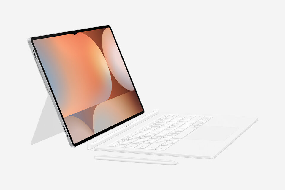 Biały tablet z klawiaturą i rysikiem, ustawiony na stojaku. Ekran wyświetla abstrakcyjną grafikę w ciepłych kolorach.