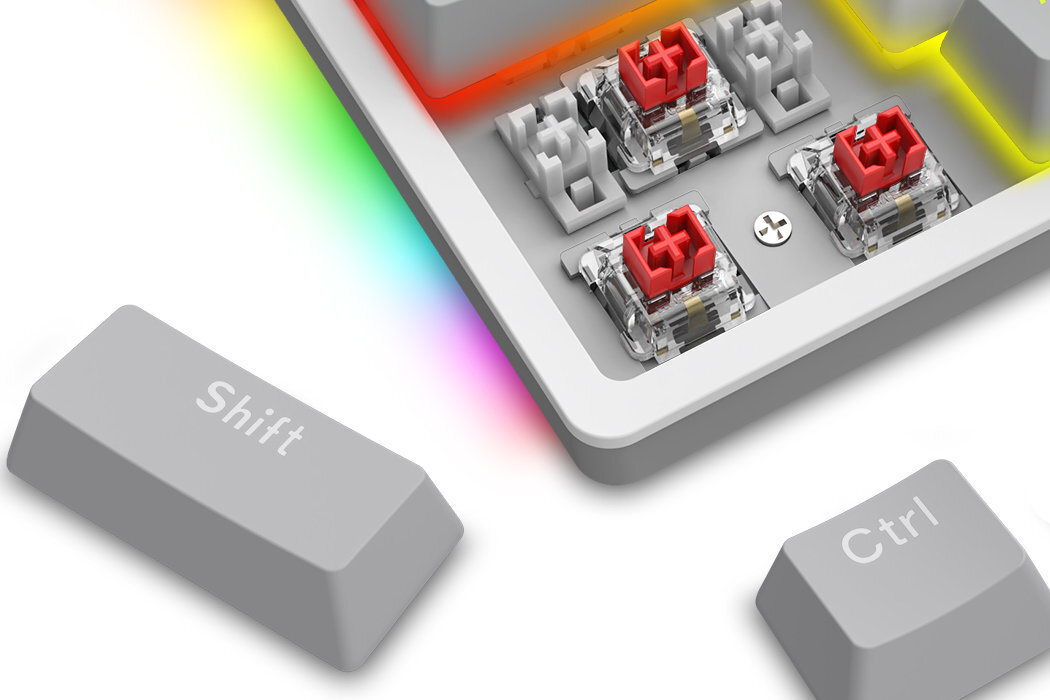 Obraz przedstawia zbliżenie na klawiaturę mechaniczną z czerwonymi przełącznikami i podświetleniem RGB. Widoczne są klawisze z napisem \'Shift\' i \'Ctrl\'.