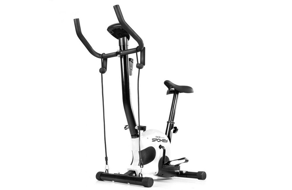 Na obrazie widoczny jest rower mechaniczny z czarnymi i białymi elementami, z logo \'SPOKEY\' na białej obudowie. Rower posiada kierownicę, siodełko oraz pedały, a także dodatkowe uchwyty z linkami do ćwiczeń.