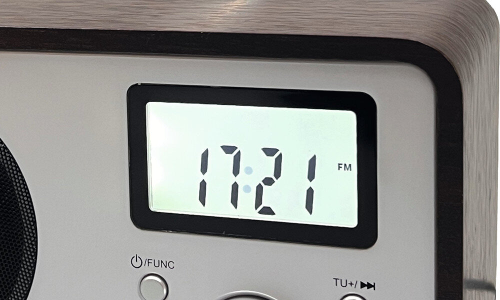 Wyświetlacz radia pokazuje godzinę 17:21 oraz oznaczenie \'FM\'. Poniżej znajduje się przycisk z napisem \'/FUNC\' oraz przyciski \'TU+/-\'.