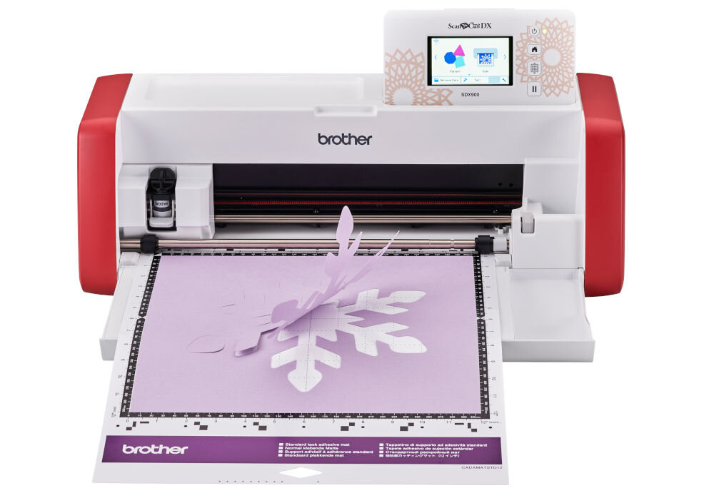 Ploter Brother ScanNCut SDX900 z wyciętym fioletowym wzorem w kształcie płatka śniegu. Na urządzeniu widoczne jest logo \'brother\' oraz ekran z kolorowym wyświetlaczem.
