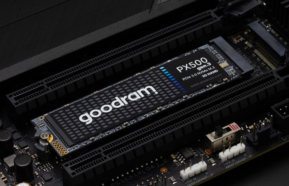 Na obrazie widoczny jest dysk SSD z napisem \'goodram PX500 gen.3 PCIe 3.0 NVMe M.2 3D NAND\' zamontowany na płycie głównej. W tle widać elementy elektroniczne i złącza płyty głównej.