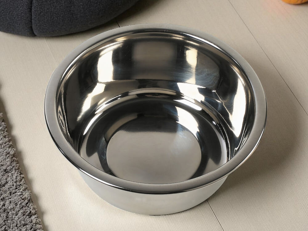 Miska dla psa i kota ZOLUX 475320 Stalowa miska o gładkiej, błyszczącej powierzchni, odbijająca światło na jasnej drewnianej podłodze obok dywanik w tle legowisko psa