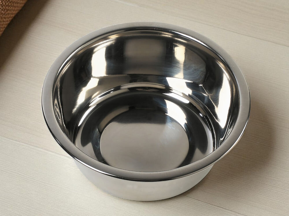 Miska dla psa i kota ZOLUX 475320  Metalowa miska z połyskiem na drewnianej podłodze obok legowisko psa Stalowa miska o gładkiej, błyszczącej powierzchni, odbijająca światło na jasnej podłodze