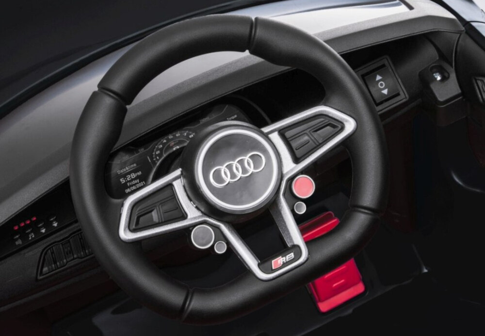 Zdjęcie przedstawia kierownicę z logo Audi, z widocznymi przyciskami i oznaczeniem \'R8\'.