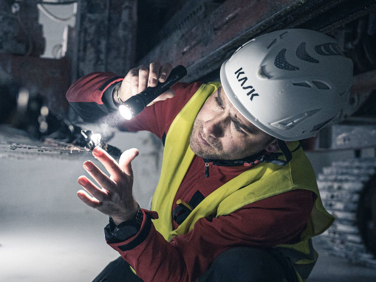 Latarka LEDLENSER P7R, świecenie, praca, oświetlenie, światło, mężczyzna oświetla część maszyny budowlanej