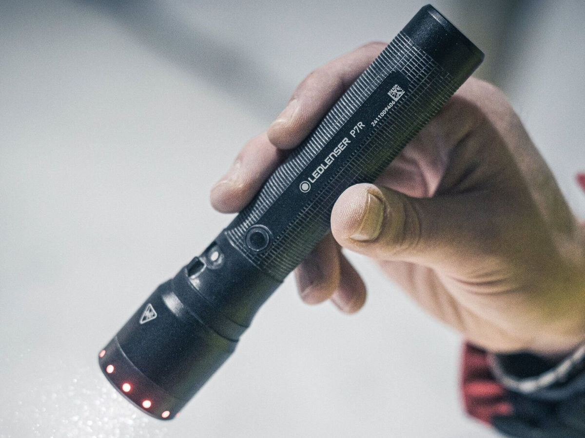 Latarka LEDLENSER P7R, Advanced Focus System, rapid focus, szeroka, skupiona, dłoń trzyma latarkę w kierunku podłogi