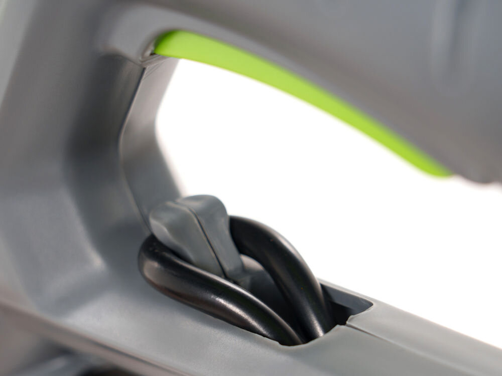 Zbliżenie na uchwyt urządzenia z widocznym czarnym przewodem i zielonym elementem wewnętrznym. Uchwyt jest wykonany z szarego tworzywa sztucznego.