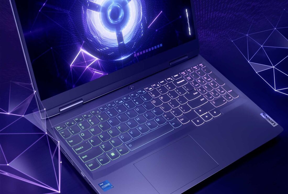 Laptop z podświetlaną klawiaturą i wyświetlaczem pokazującym futurystyczną grafikę. Na obudowie widoczne jest logo \'Lenovo\'.