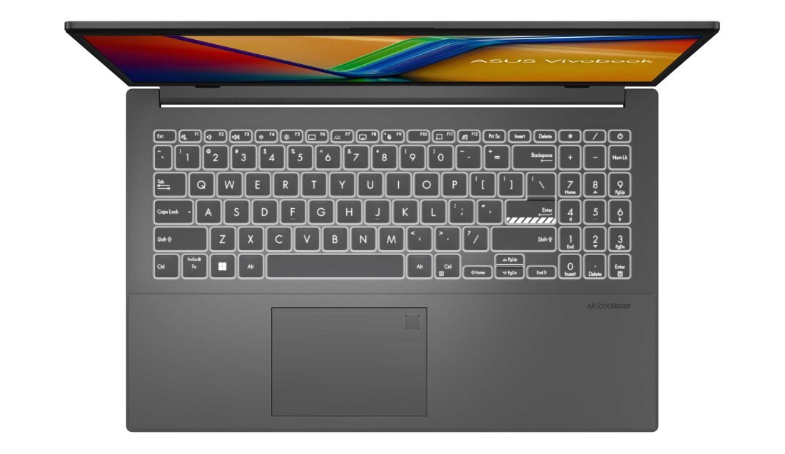 Obraz przedstawia klawiaturę laptopa z wyraźnie widocznymi klawiszami i touchpadem. Na ekranie laptopa widoczny jest kolorowy pasek oraz napis \'ASUS VivoBook\'.