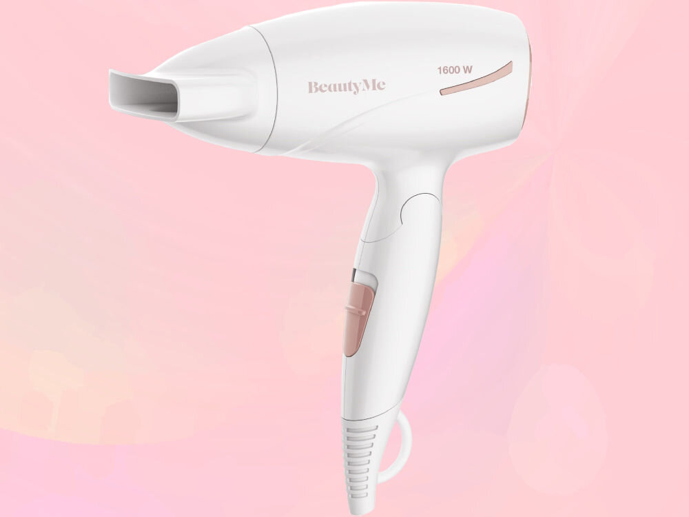 Biała suszarka do włosów z napisem \'BeautyMe\' i oznaczeniem \'1600 W\' na obudowie. Tło jest w odcieniach różu.