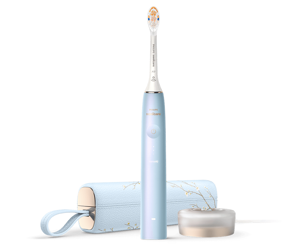 Na obrazie widoczna jest niebieska szczoteczka soniczna z napisem \'PHILIPS Sonicare\'. Obok znajduje się etui i okrągła podstawka w podobnym kolorze.