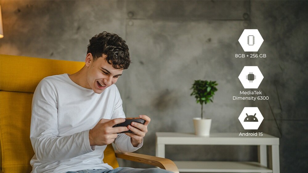 Osoba siedzi na żółtym fotelu, trzymając smartfon. Obok widoczne są ikony z napisami: \'8GB + 256 GB\', \'MediaTek Dimensity 6300\', \'Android 15\'.