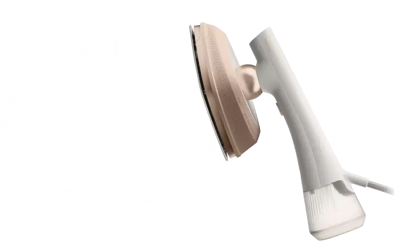 Na obrazie widoczna jest parownica do ubrań w kolorze białym z beżowymi elementami. Urządzenie ma ergonomiczny uchwyt i metalową płytę parową.