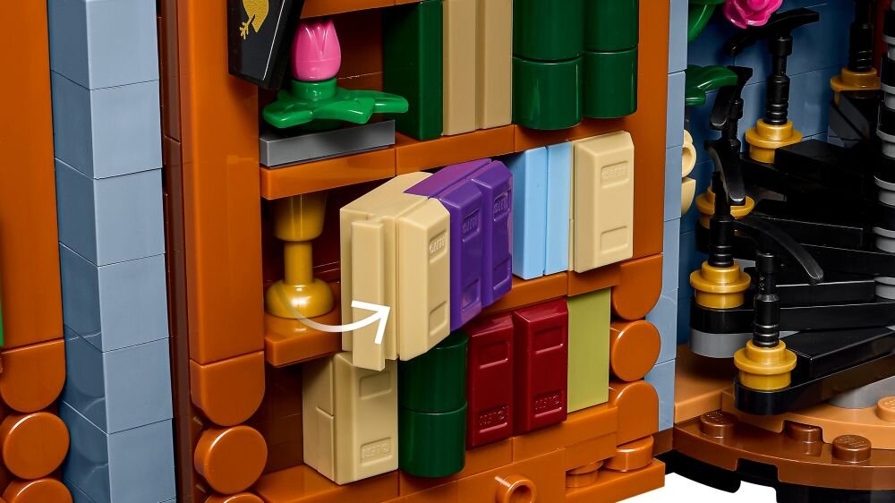 Zestaw LEGO przedstawiający półkę z książkami w różnych kolorach oraz spiralne schody z kwiatami. Widoczna jest strzałka wskazująca na jedną z książek.