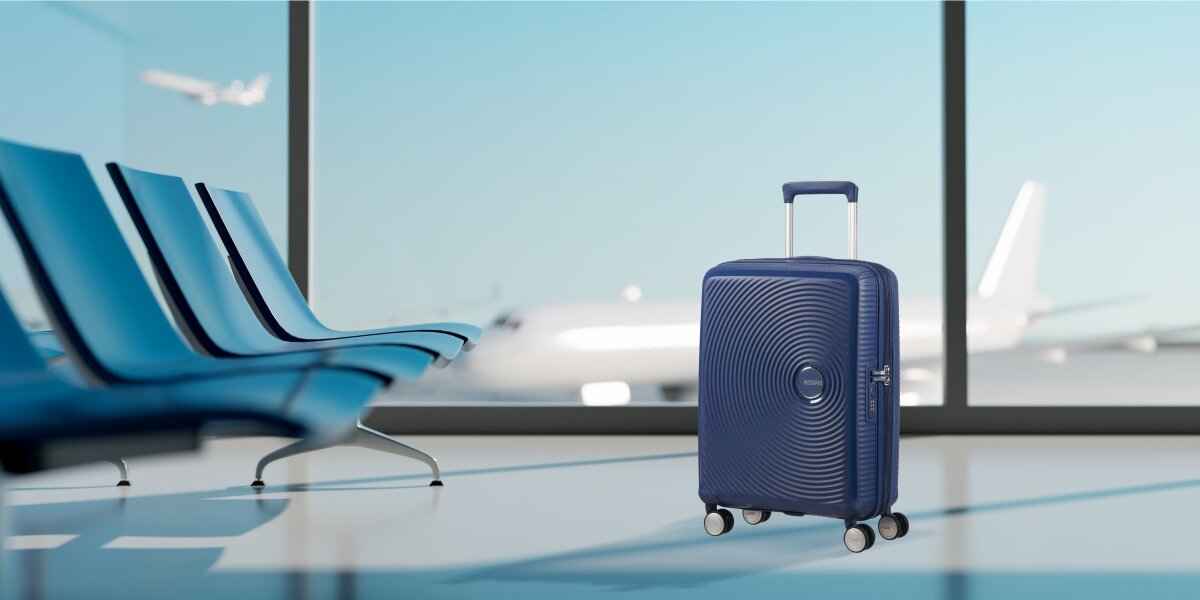 Walizka AMERICAN TOURISTER SoundBox 77 cm lifestyle lotnisko tło szyba Komfortowe podróżowanie i bezpieczeństwo bagażu Wygoda i funkcjonalność twarda konstrukcja możliwość poszerzenia zwiększenie przestrzeni z 97 na 110 l wbudowany 3 cyfrowy zamek bezpieczeństwo ochrona bagażu bezpieczeństwo wymiary 55 x 40 x 20/23 cm